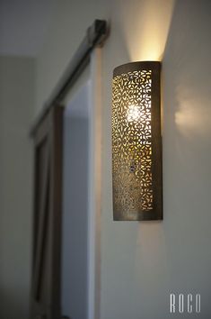 a wall light that is attached to the side of a wall in a room with white walls