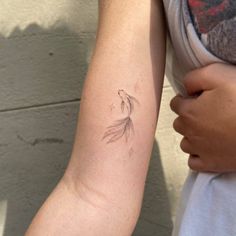 a woman's arm with a tattoo on it that has a bird flying in the air