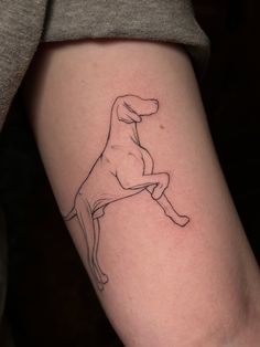 a black and white dog tattoo on the right arm, with an outline of a dog sitting on it's back legs