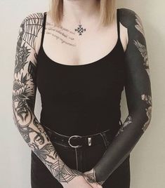 a woman with tattoos on her arms and armbands is standing in front of a white wall