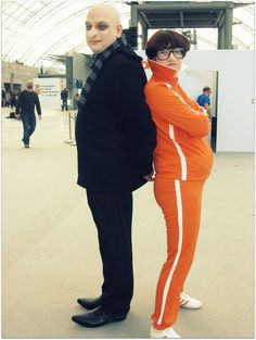 two people dressed in orange and black standing next to each other