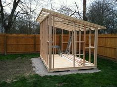 a small wooden shed sitting in the middle of a yard