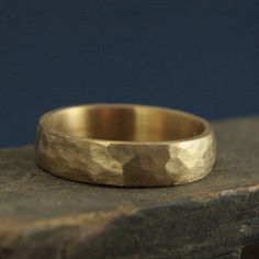 a gold wedding ring sitting on top of a rock