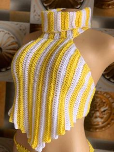 a yellow and white crocheted halter top on a mannequin's head