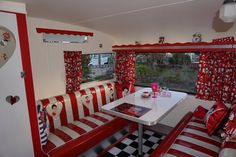 a red and white booth with checkered table cloths on the bench, two chairs in front