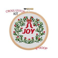 the cross stitch kit has been designed to look like a christmas wreath with an ornament