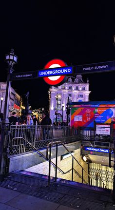 the underground sign is lit up at night