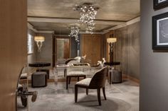 an elegant bathroom with chandelier and marble counter tops, along with two chairs