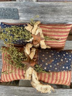 two patriotic pillows on top of each other sitting on a bench with an american flag theme