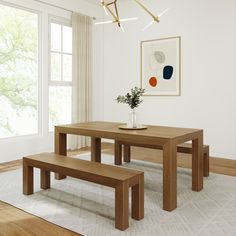 a dining room table in front of a window with an art work on the wall