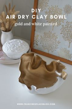 a gold and white bowl sitting on top of a table next to a framed photo