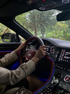 a man driving a car on a road with trees in the background