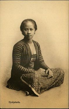 an old photo of a woman sitting on the floor