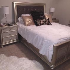 a bedroom with a bed, nightstands and two lamps on either side of the bed