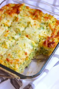 a casserole with broccoli and cheese in a glass dish on a towel