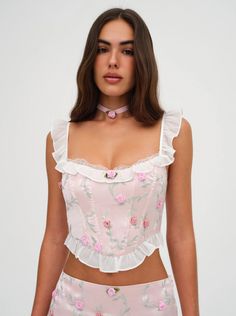 Take a leap into spring in the ultra-romantic Kimora pink corset—a satin crop corset top with allover satin rosettes, chiffon ruffles at the neckline and hem, plus a sweet and seductiver lace neckline. Make this corset top a set by pairing with our coordinating Kimora Mini Skirt. Details Lined Grommet and ribbon lacing at the back Corset Boning Fabric + Care Self: 95% Polyester/ 5% Spandex; Lining: 98% Recycled Polyester/ 2% Spandex; Contrast: 100% Recycled Polyester Eco Dry Clean recommended. Avoid cleaners that use harmful chemicals like "Perc". Coquette Clothes, Take A Leap, Skirt Details, Corset Boning, Pink Corset, Lounge Dress, Lace Neckline, Chiffon Ruffle, Hair Accessories Jewelry