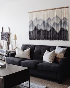 a living room filled with furniture and a painting hanging on the wall above it's headboard