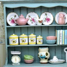 an old china cabinet with dishes and cups on it