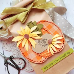 a close up of a paper bag with flowers on it and scissors next to it