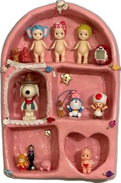 a pink toy shelf filled with lots of small figurines on top of it