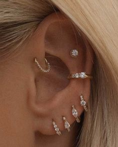 a woman with blonde hair wearing three different ear piercings