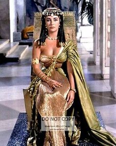 an egyptian woman in gold dress sitting on a chair