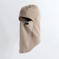 a mask hanging from the side of a white wall with a black tag on it