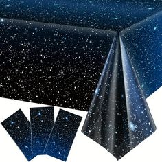 a table cloth with stars on it and four napkins in front of the table