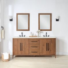 a bathroom with two sinks and mirrors on the wall