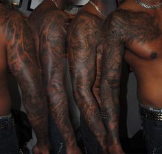 three men with tattoos on their arms and legs, one is showing off his arm