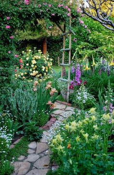 the garden is full of colorful flowers and greenery, including an old ladder in the middle