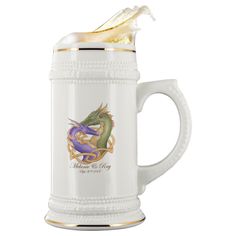 a white beer mug with a dragon on it's side and gold trimmings