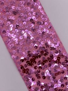 a pink tie with lots of purple sequins on the top and bottom of it