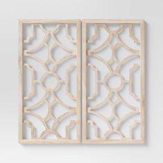 two wooden panels with carved designs on them, one in white and the other in beige