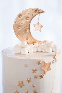 a white cake with gold stars and a crescent on top, topped with marshmallows