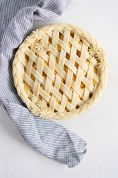 an uncooked pie sitting on top of a blue cloth next to a knife