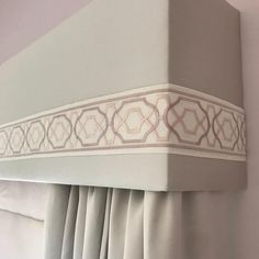 the curtain is pulled back to reveal an intricate design on the top part of the headboard