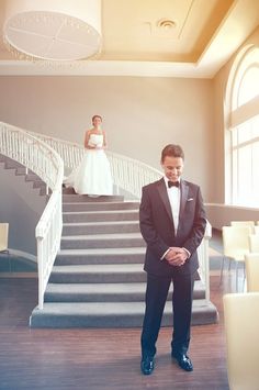 a man in a tuxedo standing next to stairs