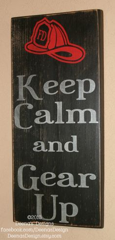 a wooden sign that says keep calm and gear up with a fireman's hat on it