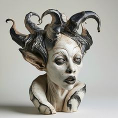 a ceramic sculpture of a woman with horns on her head