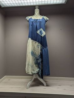 a dress is displayed on a mannequin in a room with gray walls and wood flooring