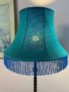 a lamp that is on top of a table with a blue shade over the lampshade