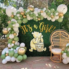 an outdoor area with balloons and decorations for a baby's first birthday party in gold, white and green