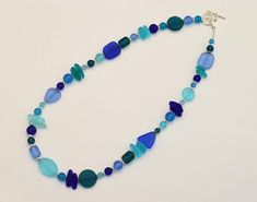 "I made this blue sea glass necklace with high-quality frosted glass that resembles ocean tumbled sea glass, but comes at a fraction of the price. Therefore, the beach glass is consistent in shapes and sizes, so your necklace will look like the one in the photos. Please note that the shape and order of the sea glass beads may vary (depending availability), but the overall look will remain the same. The beach glass necklace is light, but very sturdy. I make these sea glass necklaces to be 16\"-22 Adjustable Blue Recycled Glass Jewelry, Adjustable Blue Jewelry Made Of Recycled Glass, Adjustable Blue Jewelry With Recycled Glass, Ocean-inspired Blue Sea Glass Necklaces, Blue Sea Glass Necklaces For Jewelry Making, Blue Sea Glass Jewelry Gift, Blue Recycled Glass Jewelry With Ocean-inspired Style, Blue Sea Glass For Jewelry Making, Blue Recycled Glass Jewelry, Ocean-inspired