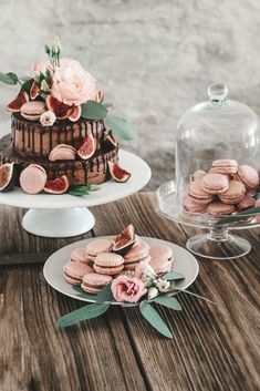 there is a cake on the table with flowers and cookies next to it that have been cut in half