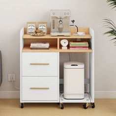 a white cabinet with drawers and a trash can next to a chair in a room