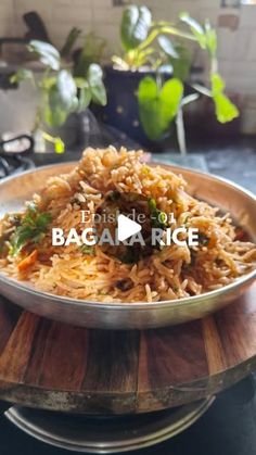 a metal bowl filled with rice on top of a wooden table