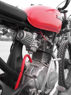 a red and black motorcycle parked on the street