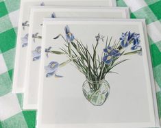 three cards with blue flowers in a vase on a green and white checkered tablecloth