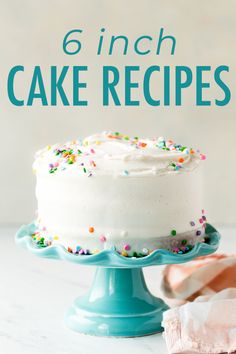 a cake with white frosting and sprinkles sitting on top of a blue plate